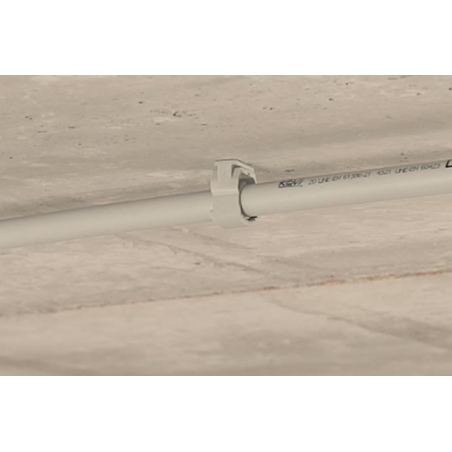 Obrázek aplikace chytré svorky na hřebíky, která drží trubku na stropě. 